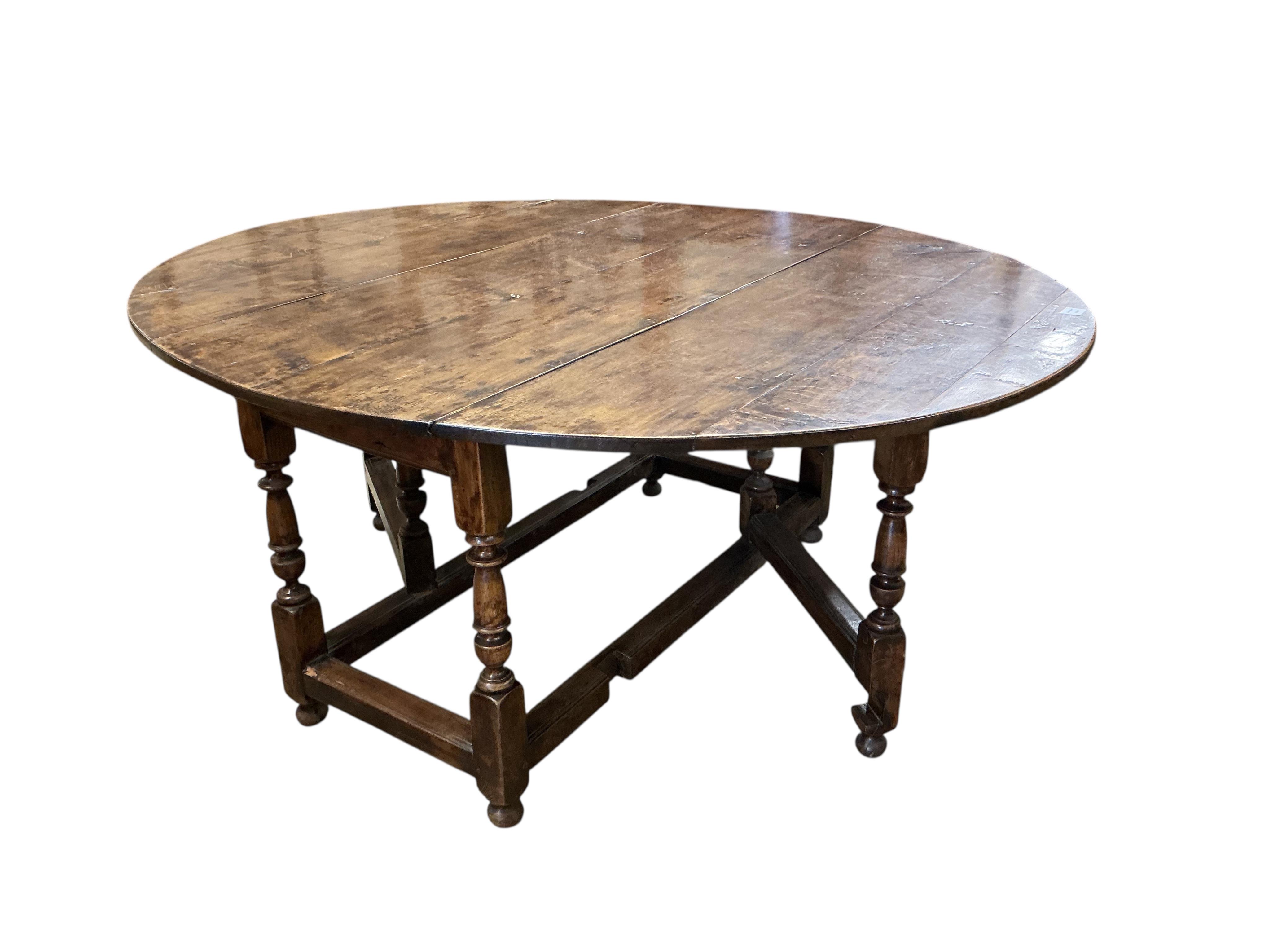 An early 17th century style oak gateleg dining table incorporating earlier elements, width 151cm, depth 62cm, height 75cm